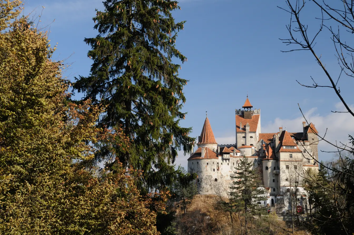Bran Castle in Romania, behind green trees