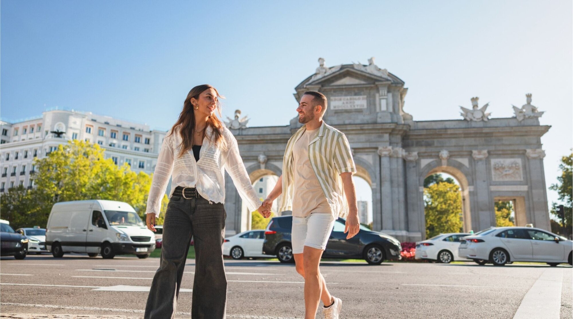 Casal hispânico visitando a Puerta de Alcalá em Madri.