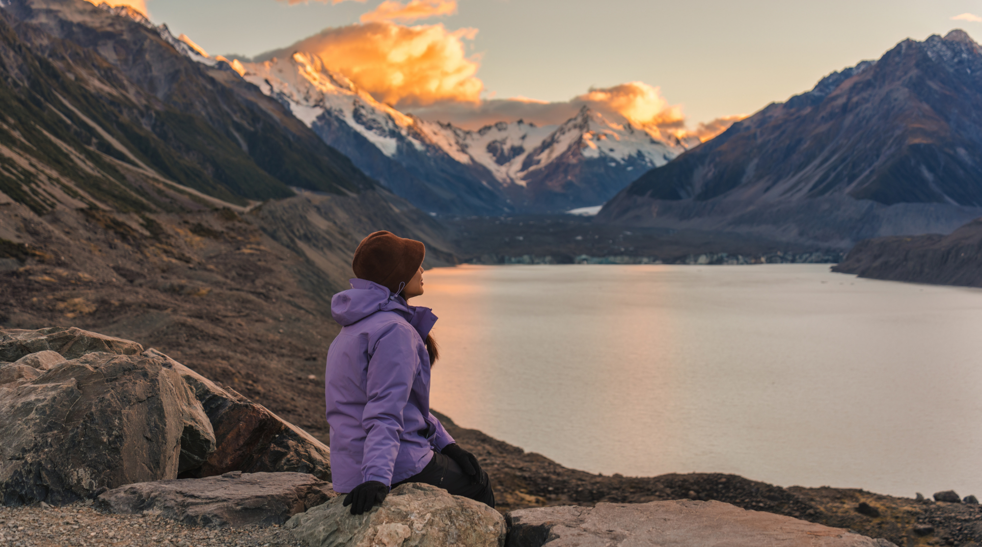 Eine Frau sitzt in den Bergen von Neuseeland und benutzt ihre SIM-Karte