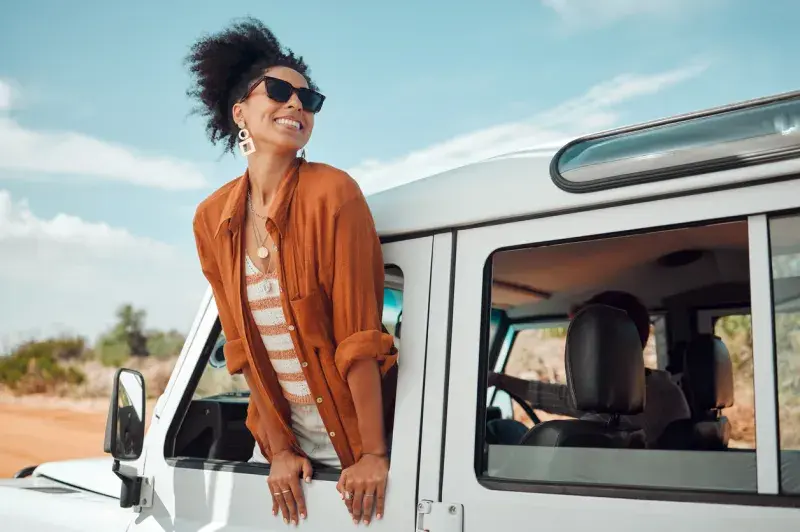 Mujer viajera asomada a la ventana de una camioneta disfrutando del paisaje desértico con datos de eSIM para viajes