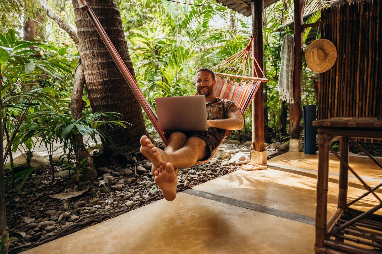 Ein Mann liegt in einer Hängematte und arbeitet