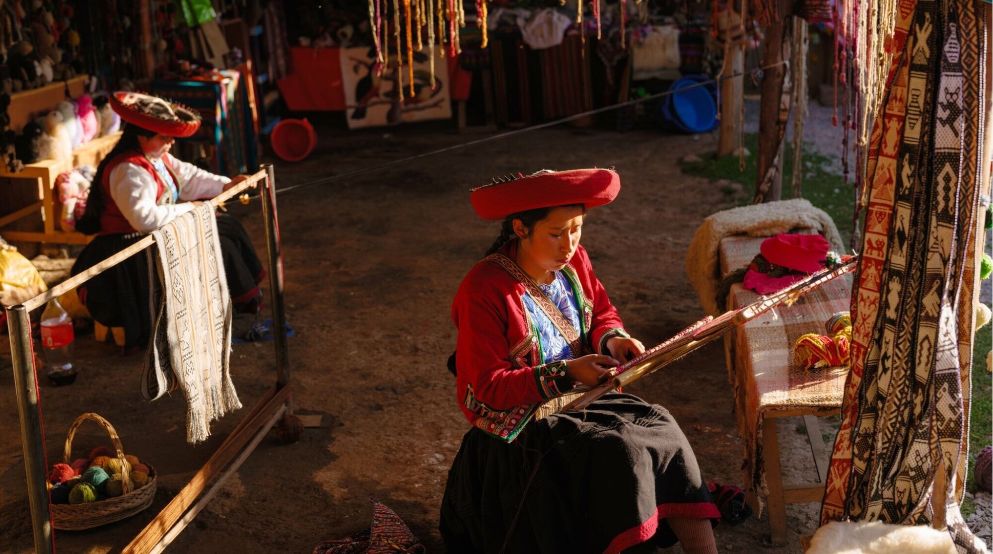 Duas mulheres indígenas do Vale Sagrado tecendo artesanato em aldeia tradicional