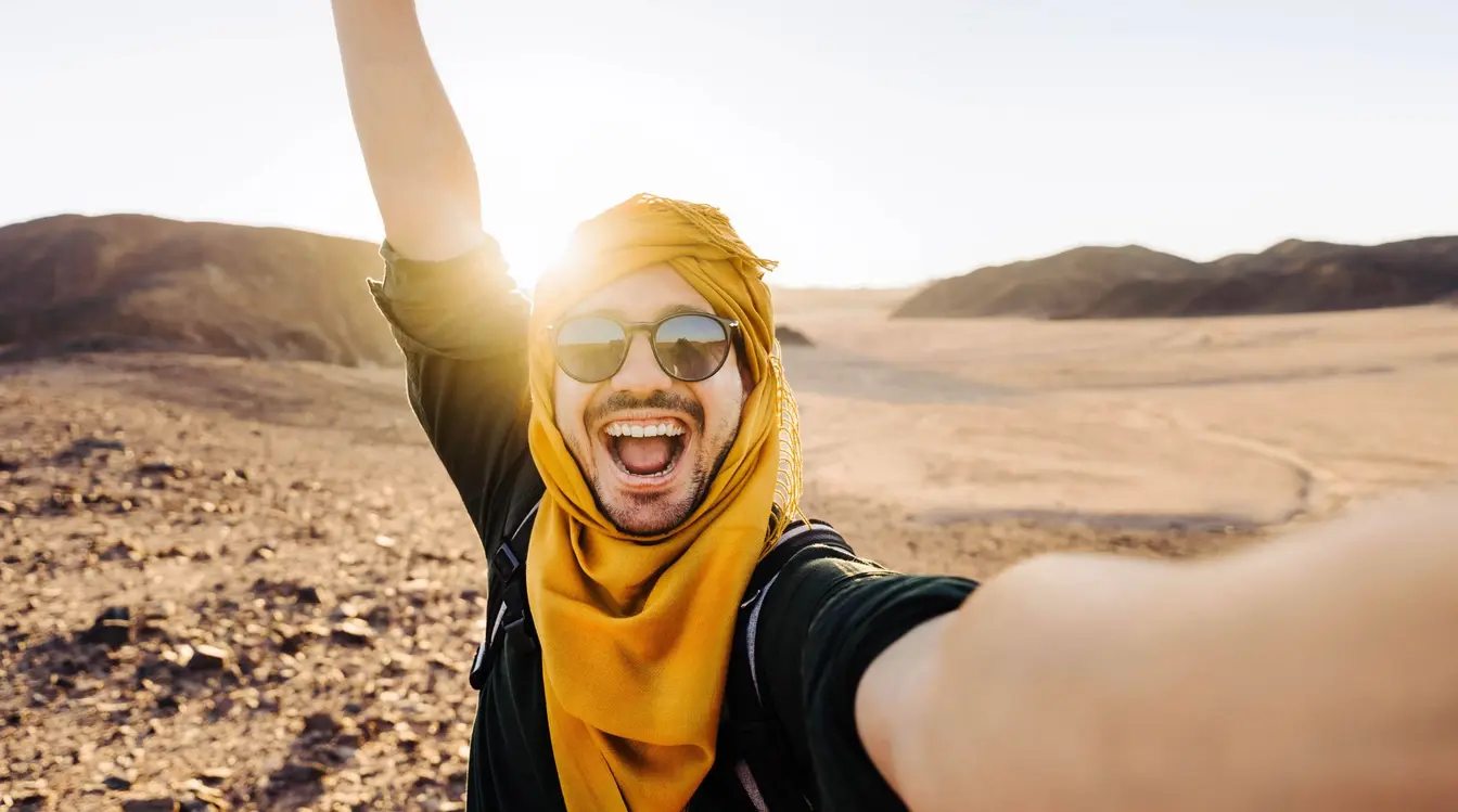 Mann macht Selfie-Bild mit Smartphone und eSIM in Ägypten in der Wüste