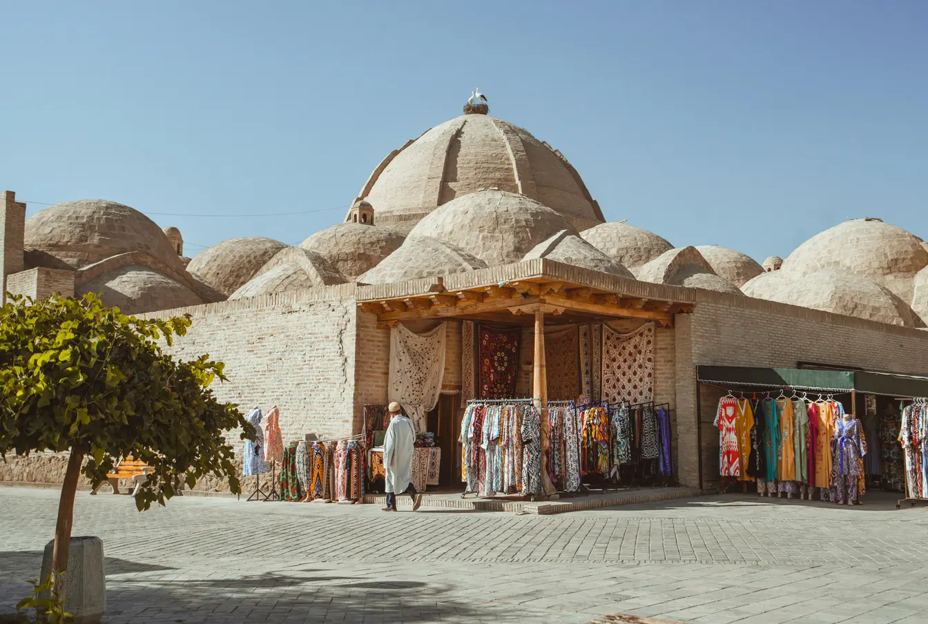 Bazar in città vecchia dell’Uzbekistan con uomo che cammina sulla strada