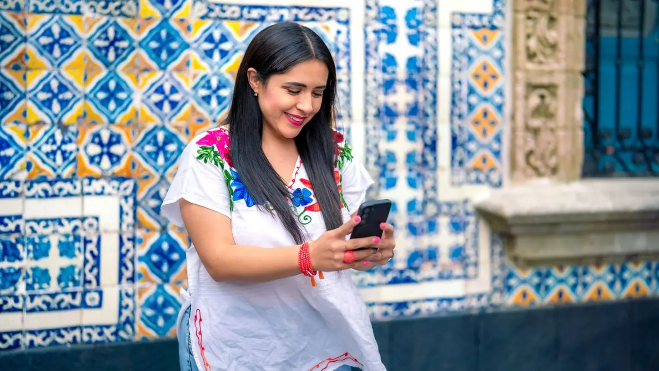 Viajera usando su celular durante un viaje en México, con datos móviles para moverse por Guadalajara y sus alrededores.
