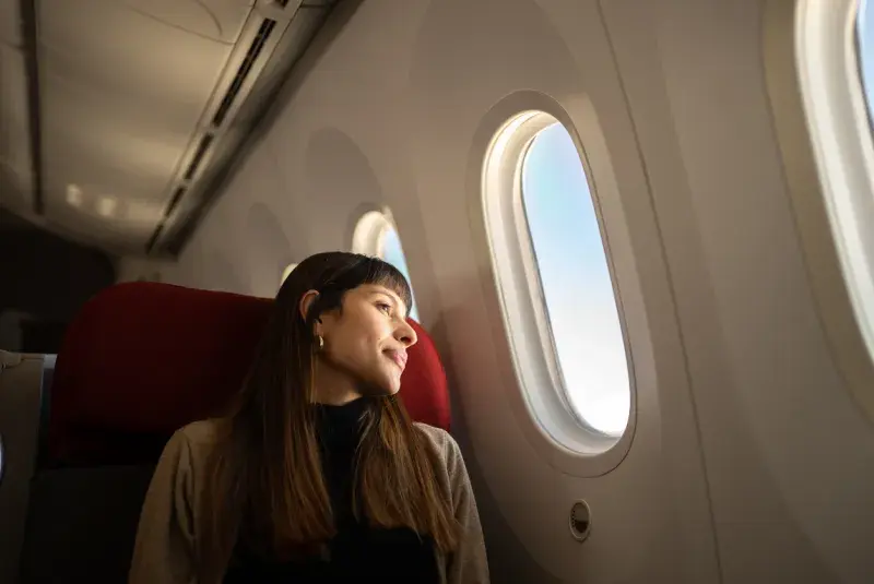 Viajera en avión rumbo a Cancún con eSIM de Airalo ya activada antes de aterrizar en México