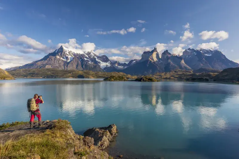 Fotógrafo frente al lago Pehoé en Torres del Paine, Patagonia, destino cubierto por la eSIM Latinoamérica de Airalo.