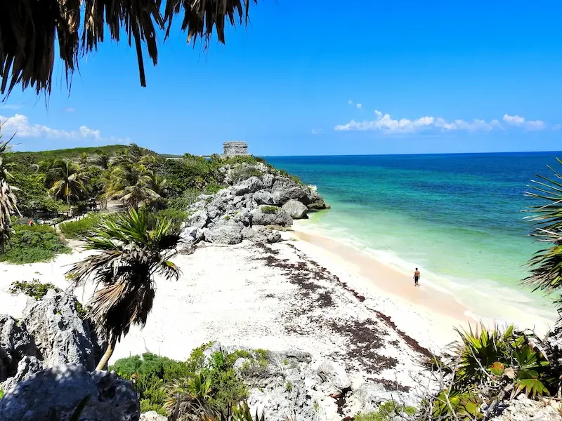 Playa de arena blanca en Tulum con ruinas mayas frente al mar Caribe y agua turquesa. 