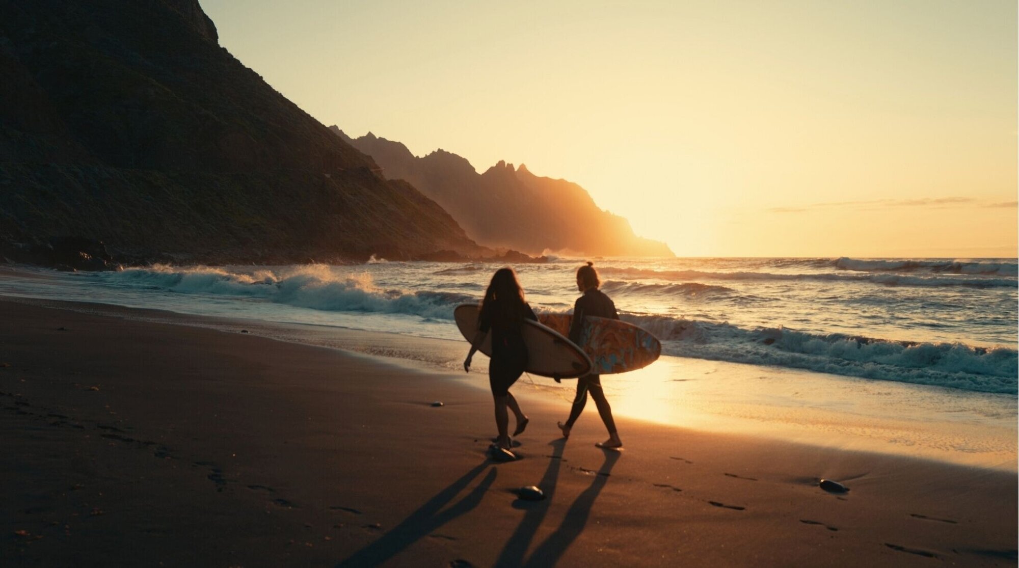 Surfistas entrando al mar en una playa de Tenerife, Islas Canarias.