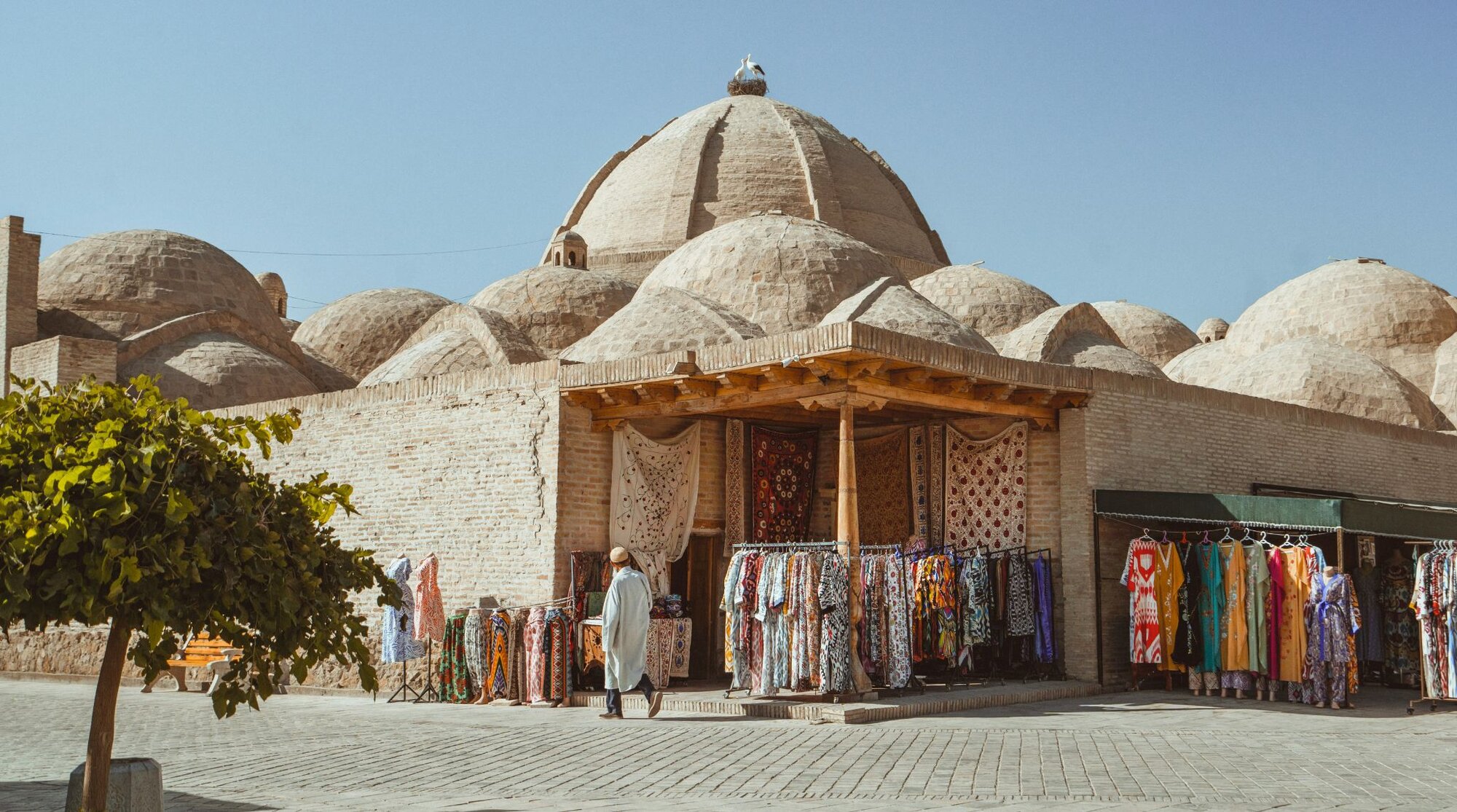 Bazar in città vecchia dell’Uzbekistan con uomo che cammina sulla strada