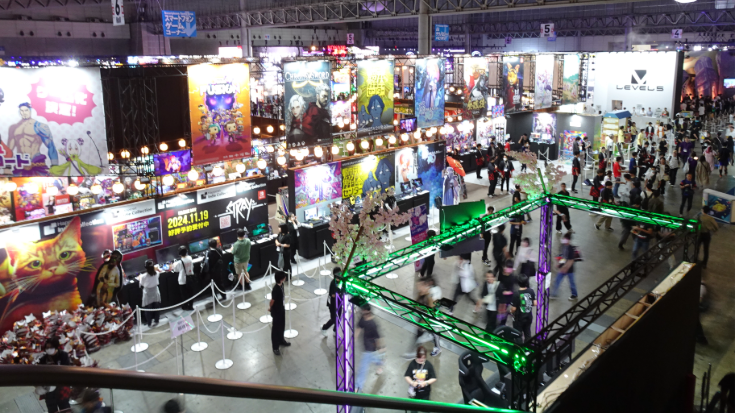 Colourful exhibition floor at Tokyo Game Show with neon lights, giant game posters, and crowds of fans exploring booths — capturing the excitement of the Tokyo game expo and the energy of Tokyo Game Show 2025.