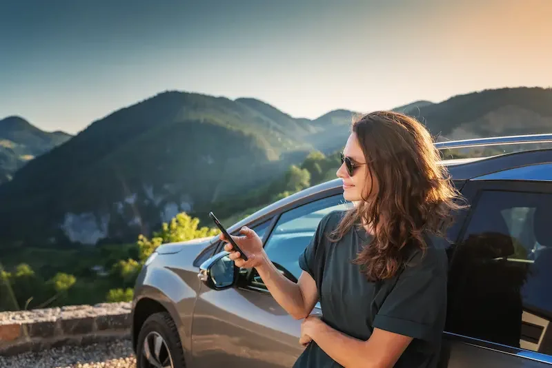 Mujer viajera revisando su conexión a internet antes de un viaje por carretera