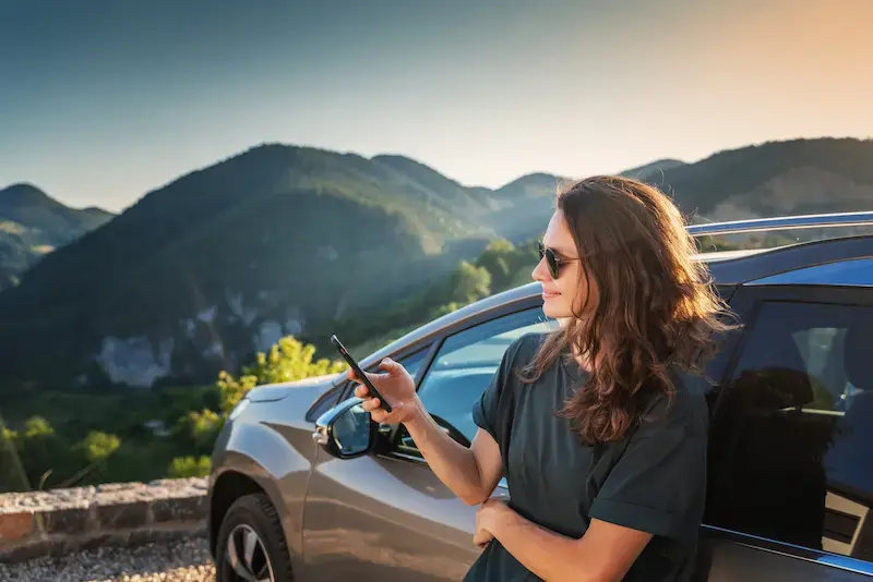 Mujer viajera revisando su conexión a internet antes de un viaje por carretera