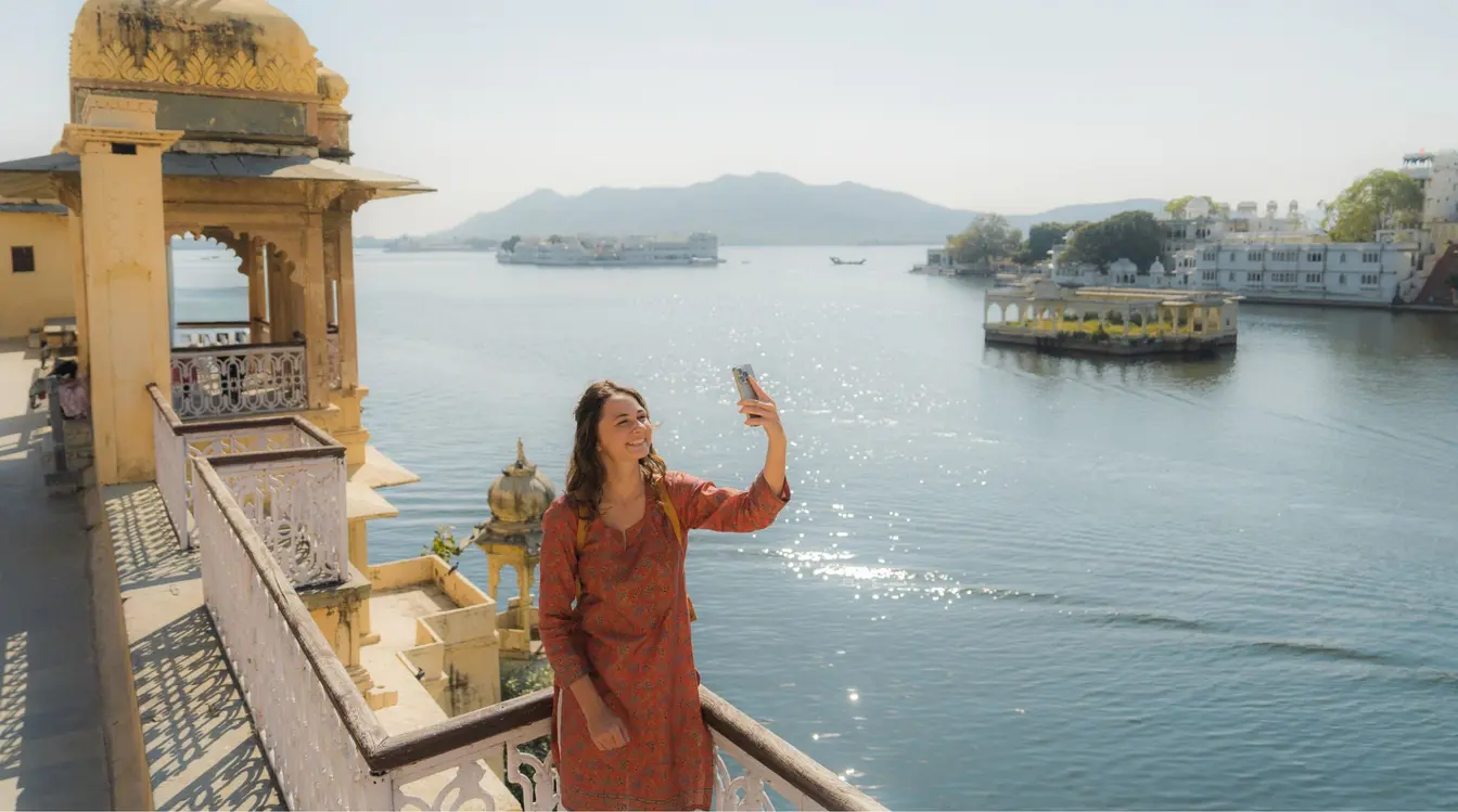 Frau, die mit Smartphone fotografiert, erkundet Udaipur mit einer SIM-Karte in Indien