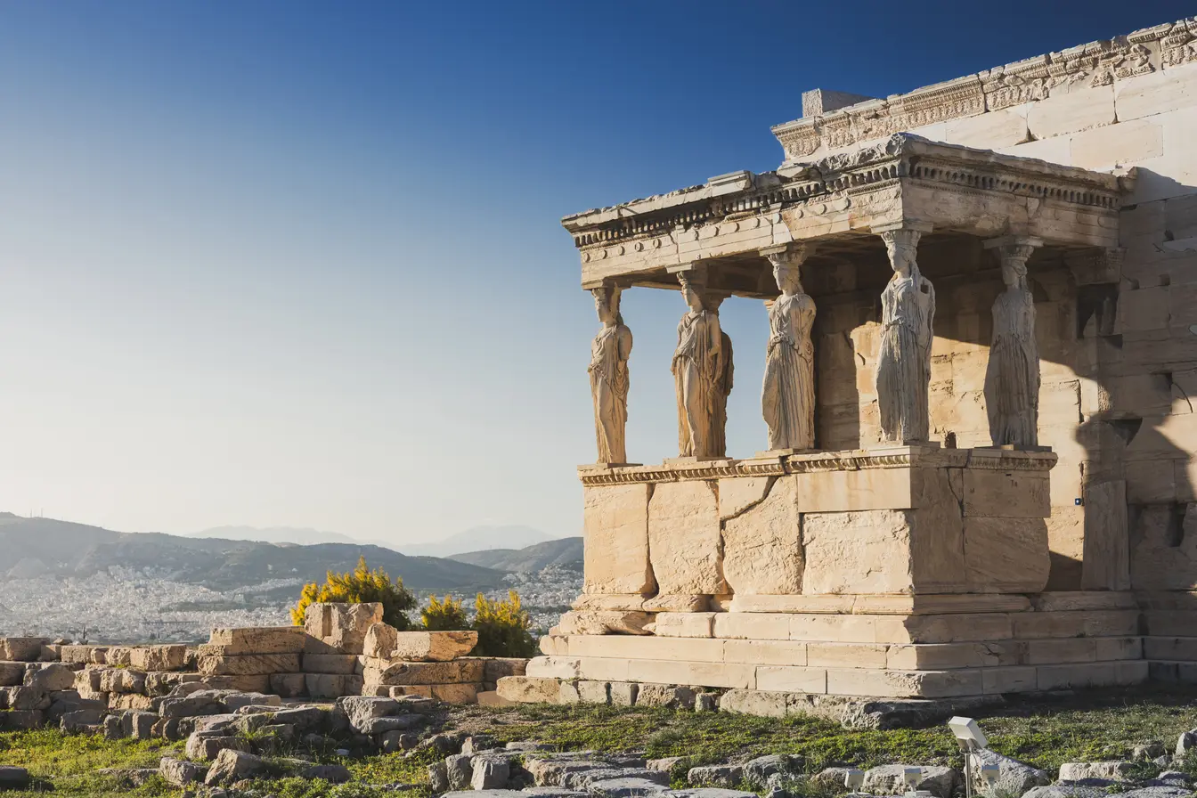 Portico delle Cariatidi dell’Eretteo sull’Acropoli di Atene sotto un cielo blu in una giornata primaverile di maggio.
