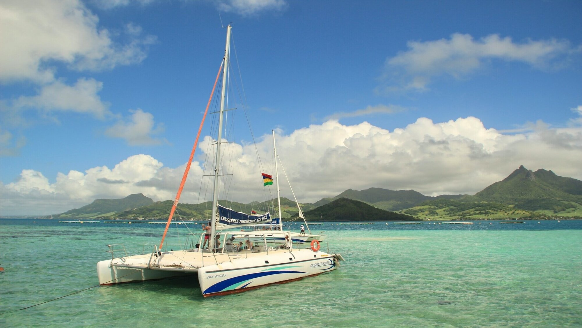 A boat on a body of water with mountains at a distance in Mauritius
