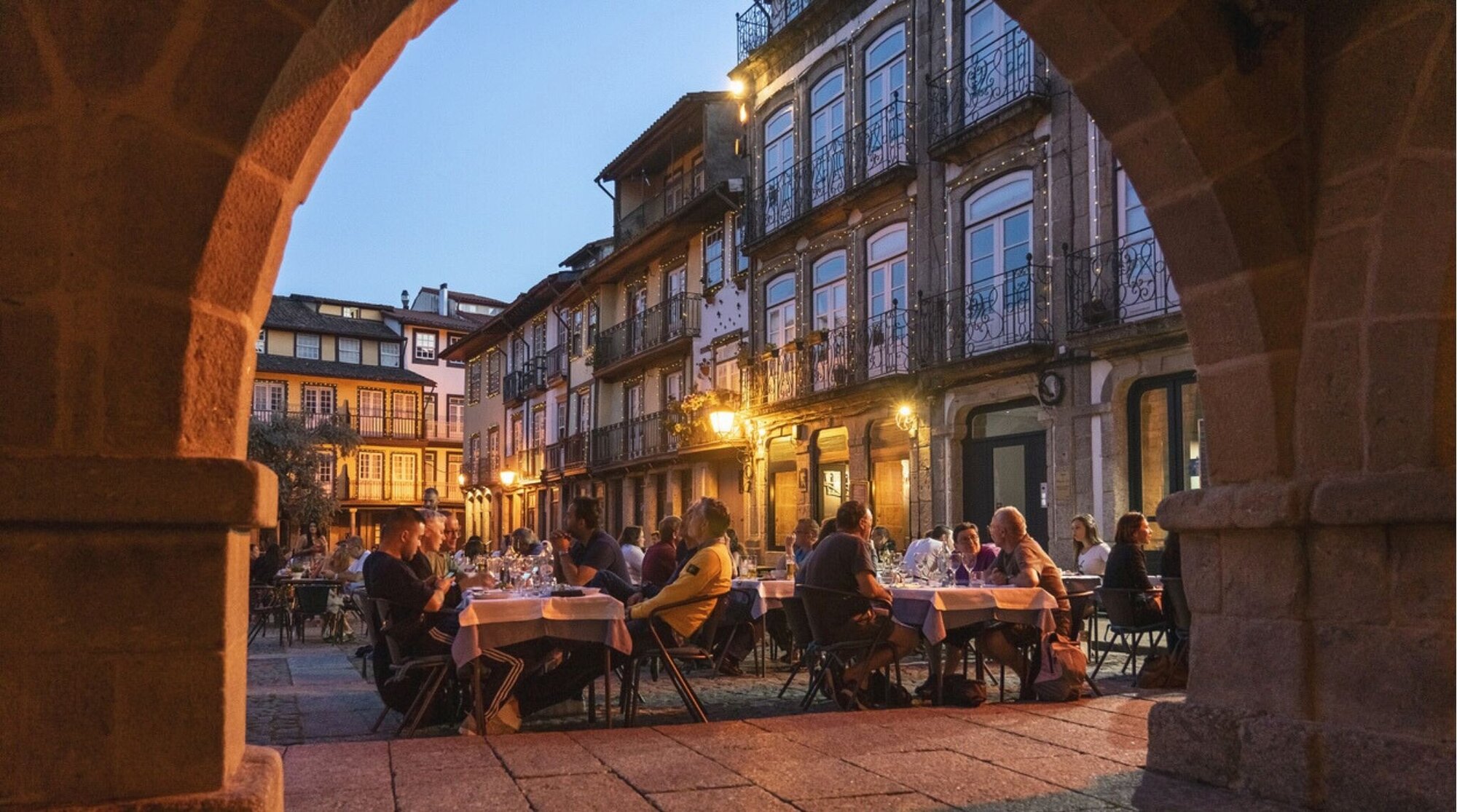 13 de maio de 2019: Pessoas relaxando nas áreas externas dos restaurantes da Praça de São Tiago, no centro histórico de Guimarães, classificada como Patrimônio Mundial pela UNESCO.