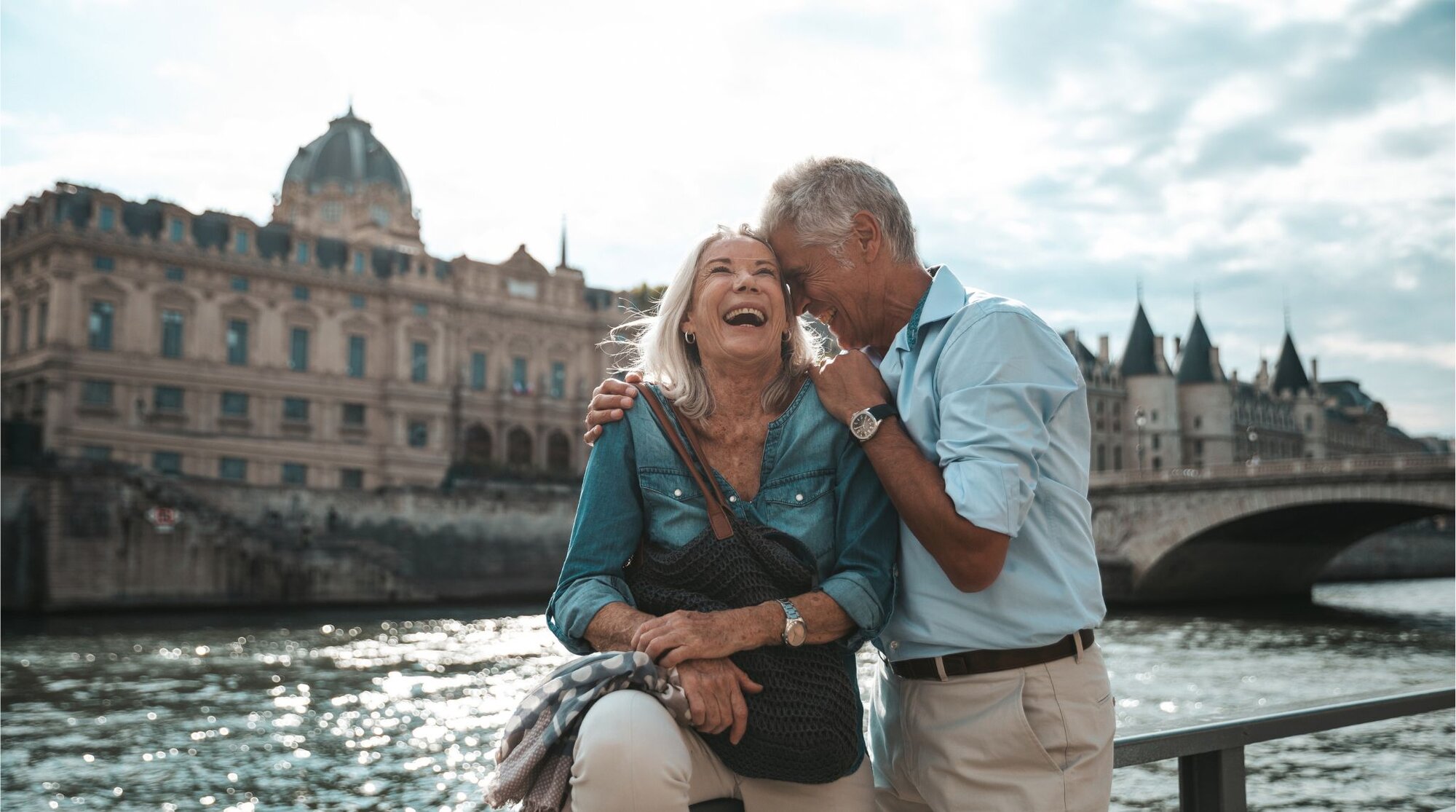 Casal de turistas na melhor idade num passeio romântico pelo Sena.