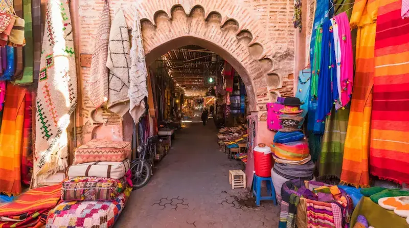 Sacs colorés remplis d’épices, de fruits secs et d’herbes aromatiques alignés dans un souk aux épices à Marrakech