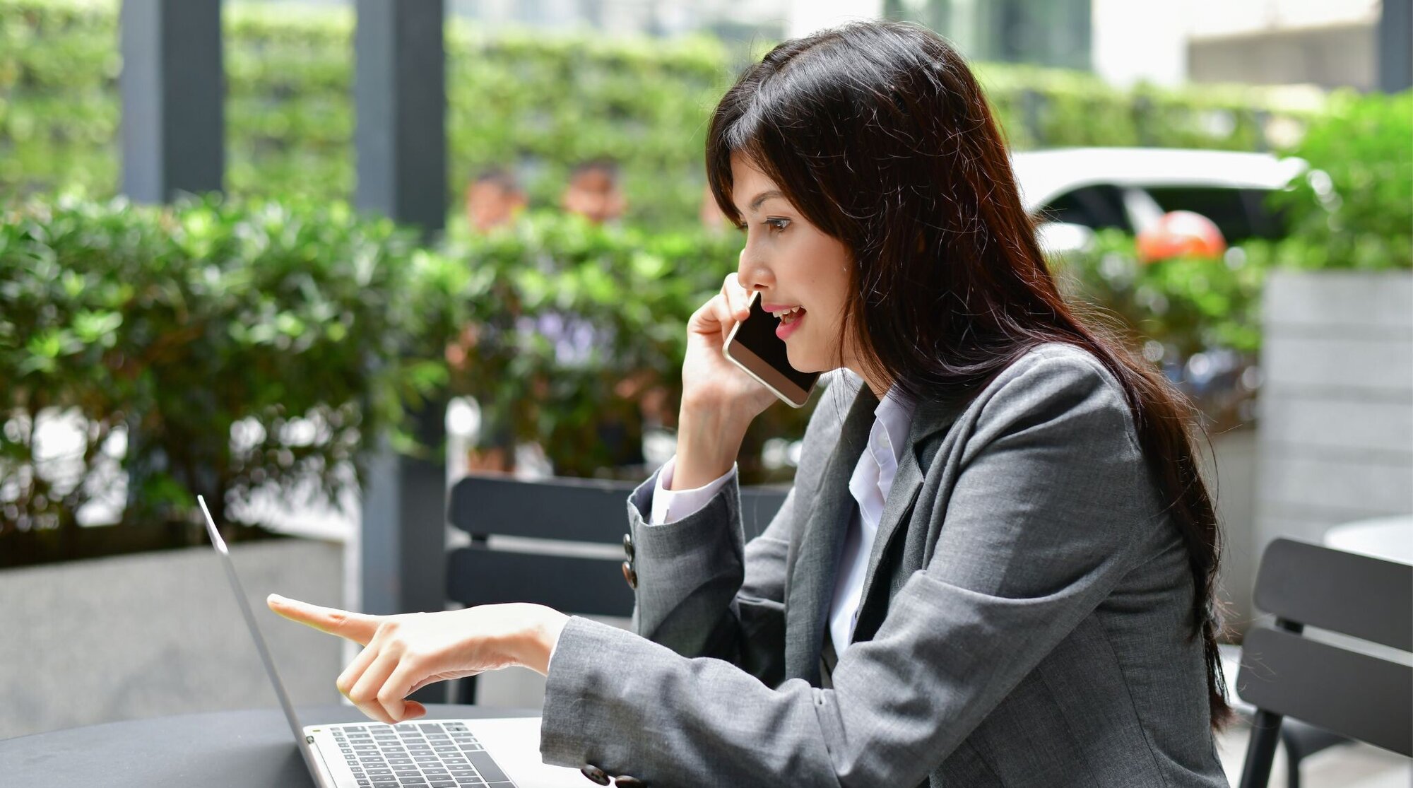 パソコンを見ながら電話会議する人