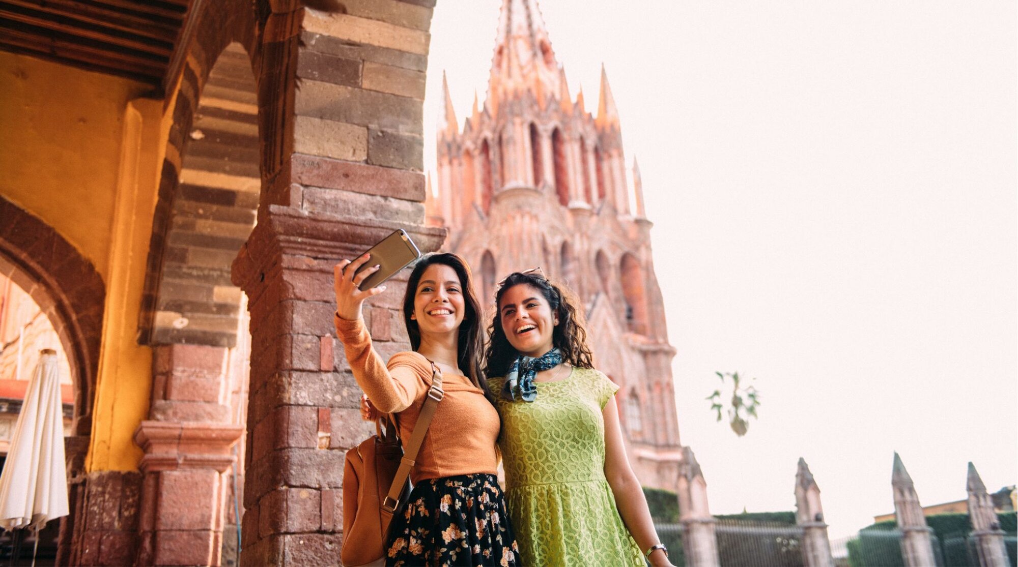 Dos viajeras tomándose una foto en una ciudad colonial durante un roadtrip por el centro de México.