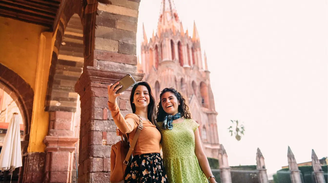 Dos viajeras tomándose una foto en una ciudad colonial durante un roadtrip por el centro de México.