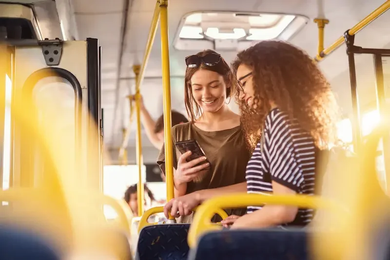 Amigas consultando direcciones del transporte público durante su viaje
