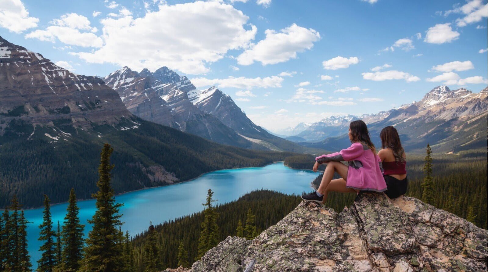 Lugar mais bonito do mundo. Duas amigas desfrutam da bela paisagem das Montanhas Rochosas canadenses em um dia ensolarado de verão. Foto tirada no Lago Peyto, Parque Nacional de Banff, Alberta, Canadá.