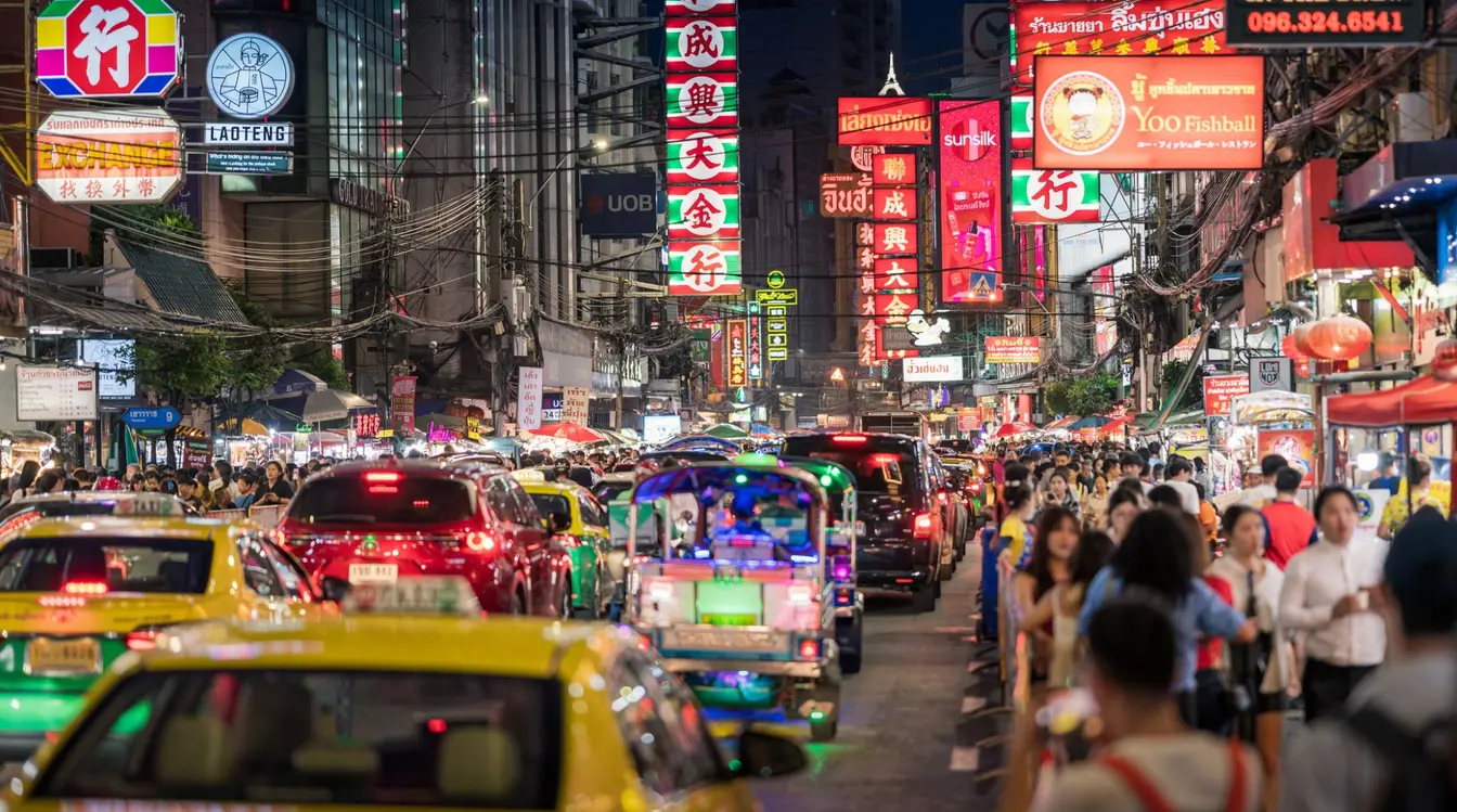 Eine befahrene Straße in bangkokg in Thailand, auf der potentielle Gefahren für Touristen lauern