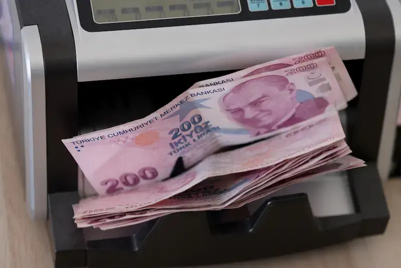 Billets de 200 livres turques sortant d’une machine de comptage dans un bureau de change en Turquie.