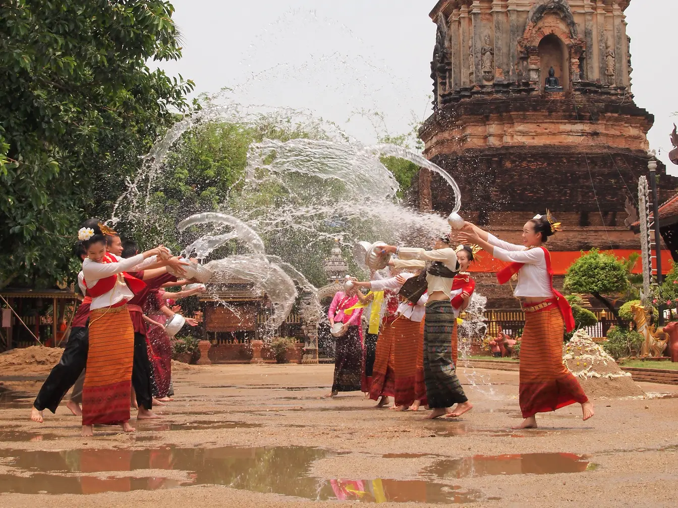 Women splashing each other at the temple during Songkran.