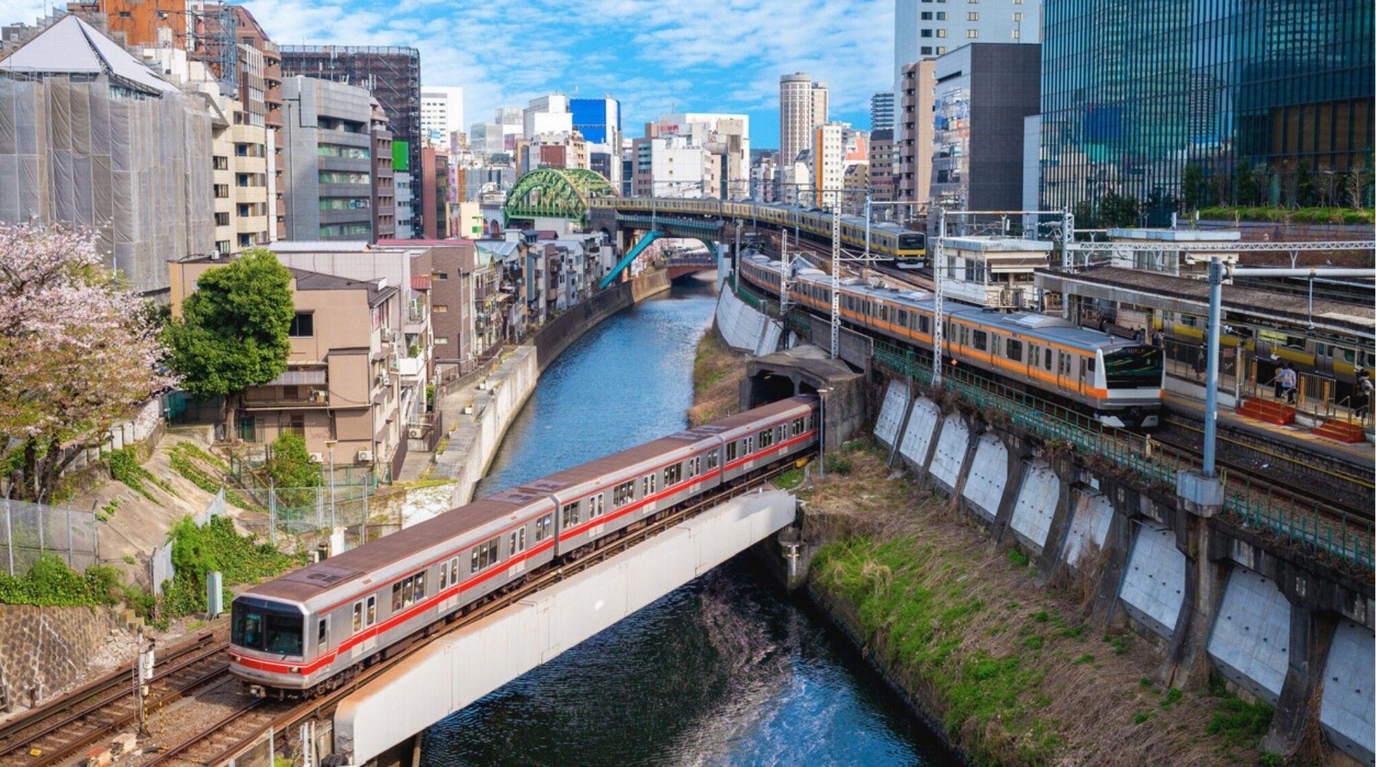 Interior del metro de Tokio con pasajeros sentados y agarrados a las barras.