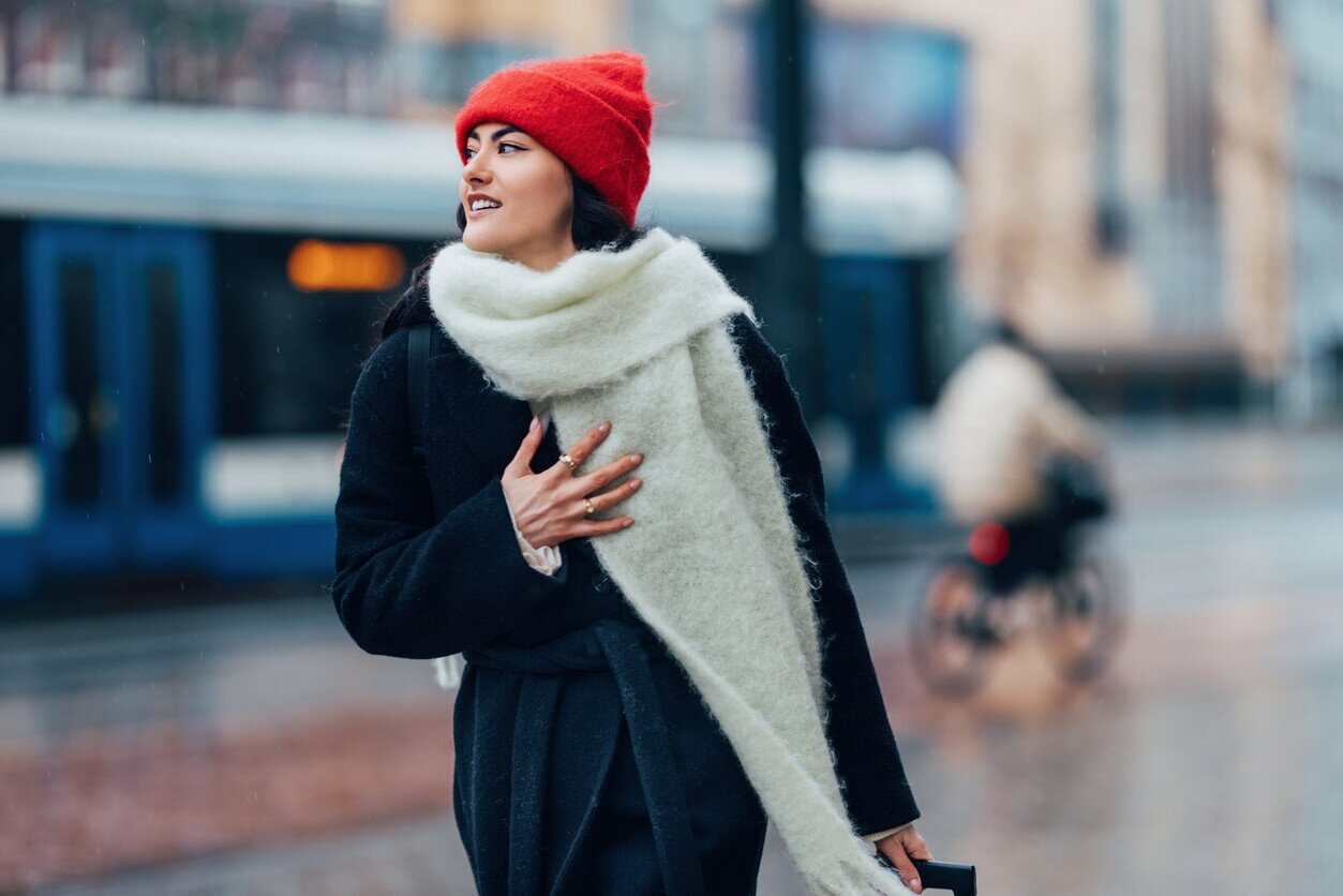 Woman with a red hat and a fashionable scarf walking