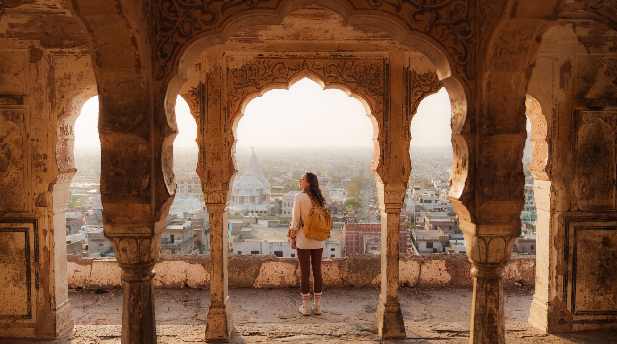 Frau mit SIM-Karte in Indien, die bei Sonnenuntergang auf das Stadtbild von Jaipur schaut
