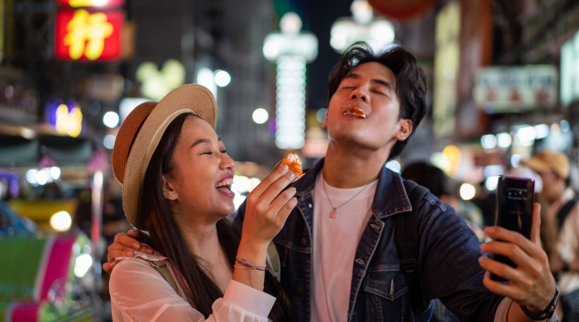 Zwei Menschen auf einem Markt in Japan nutzen Apps, um ihr Essen online zu teilen