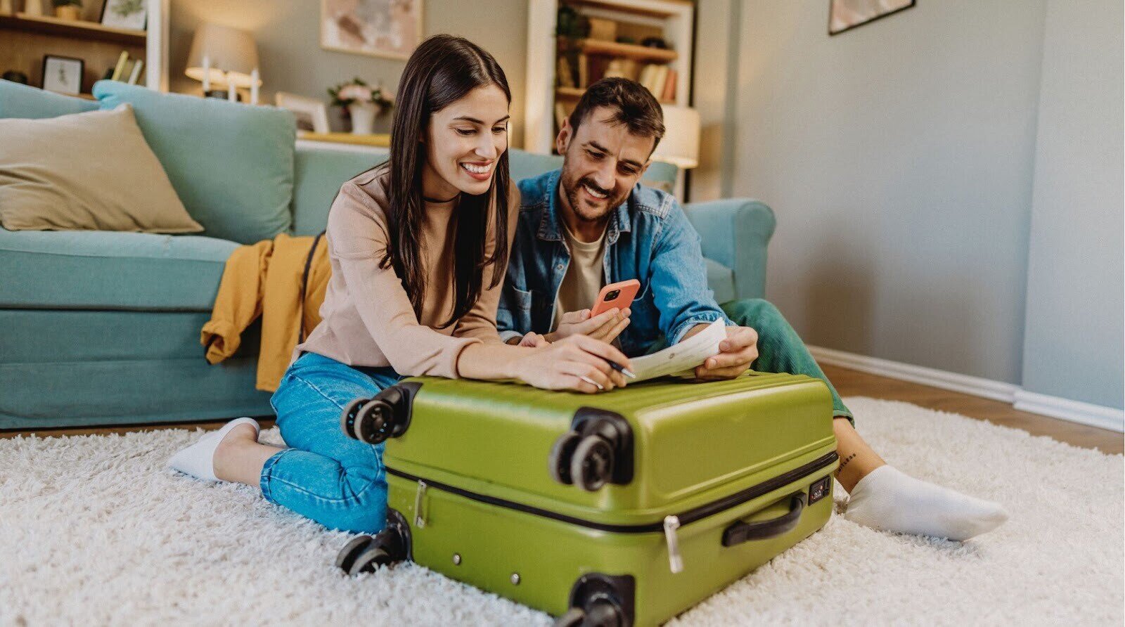 Casal na sala de casa planejando viagem internacional.