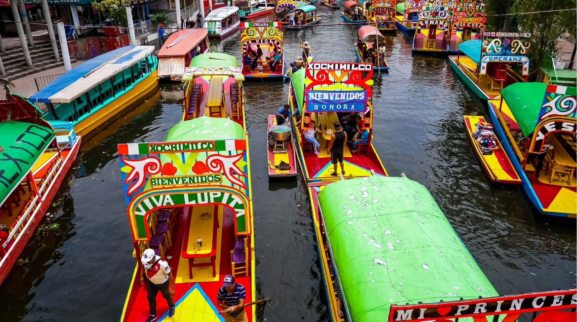 Vista das trajineras, as embarcações vibrantes e tradicionais, atracadas nos canais de Xochimilco.