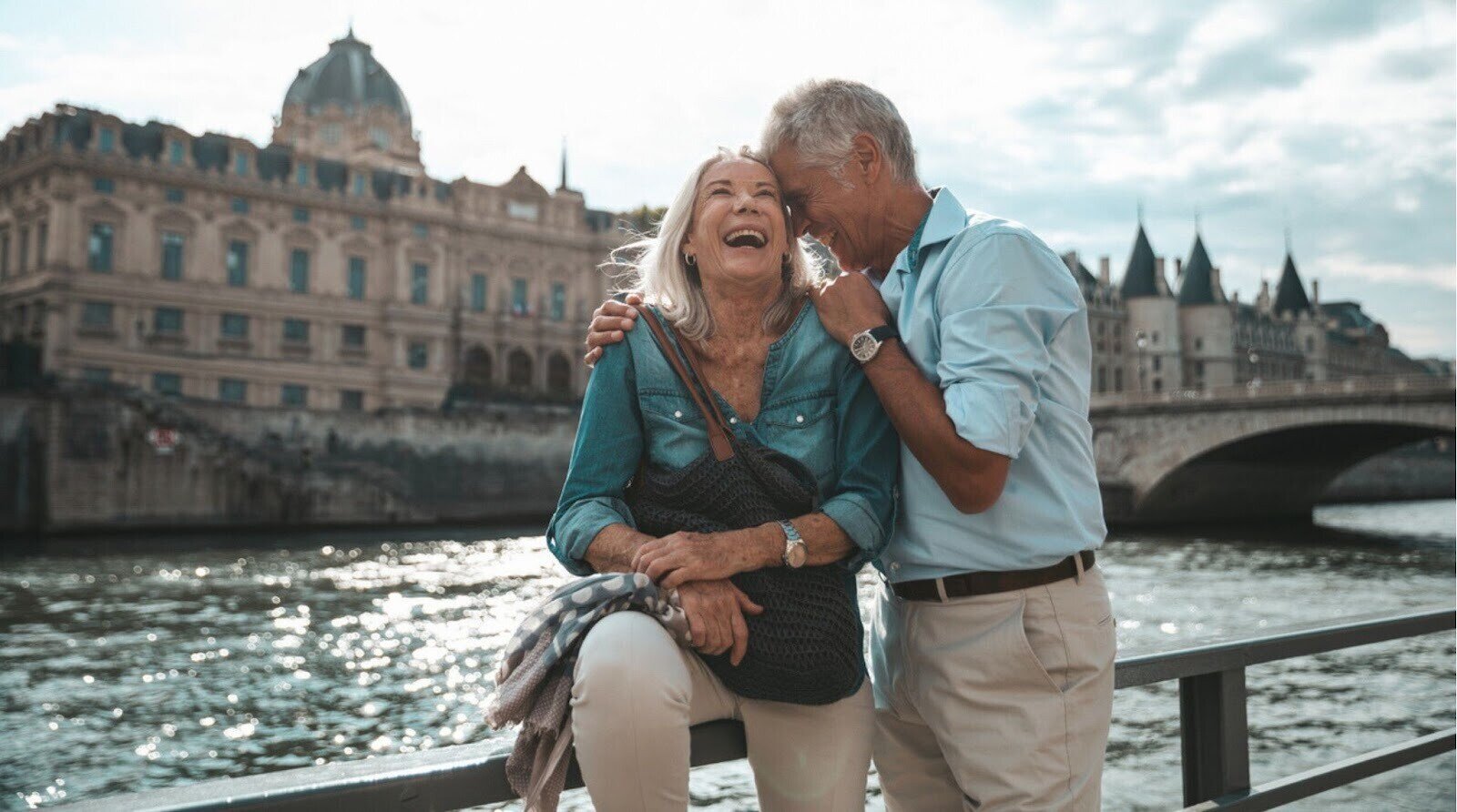 Casal de idosos fazendo uma pausa em Paris, relaxando às margens do Rio Sena.