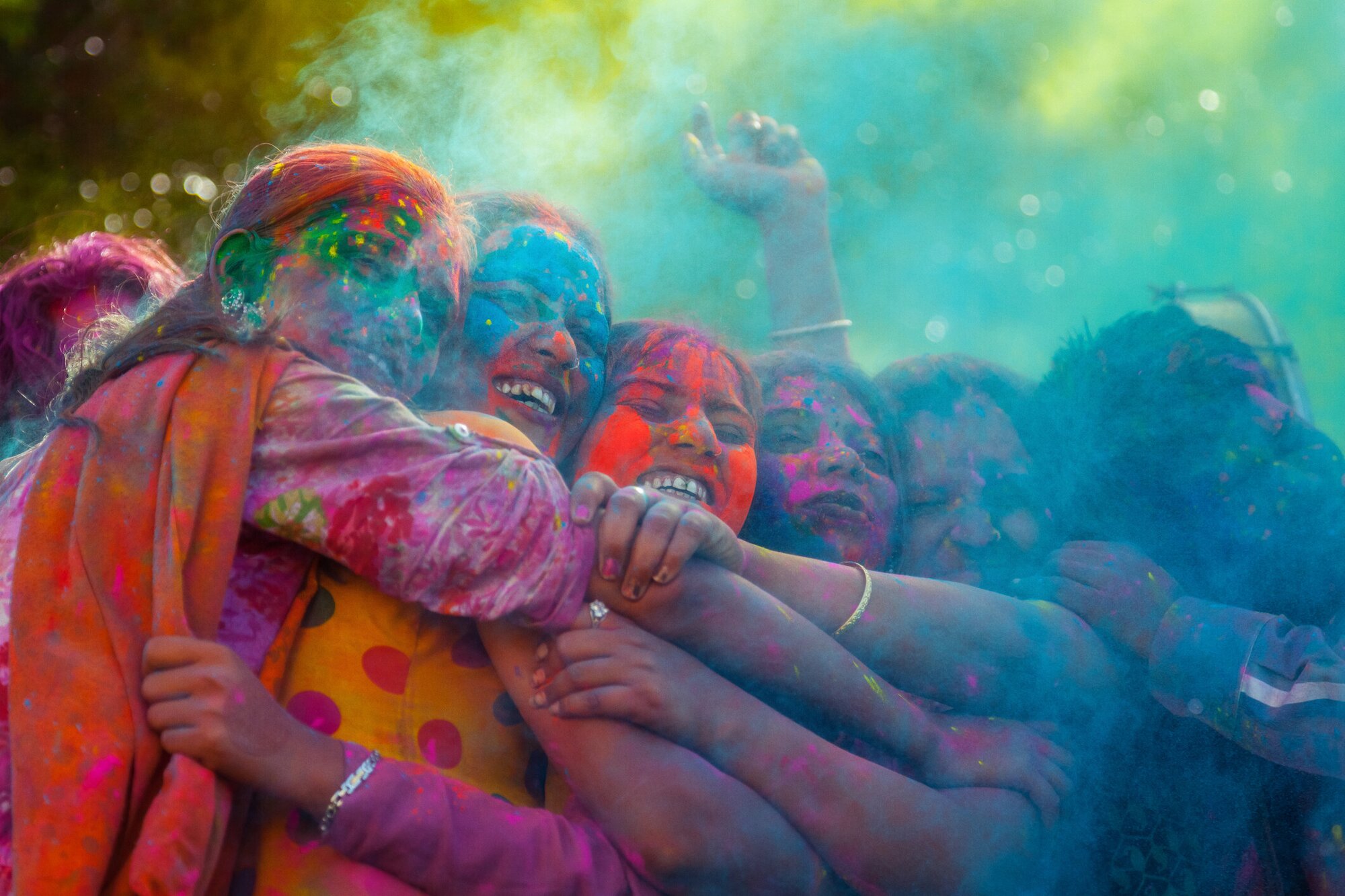 Frauen beim Holi Fest in Indien umarmen sich und lachen voller Freude