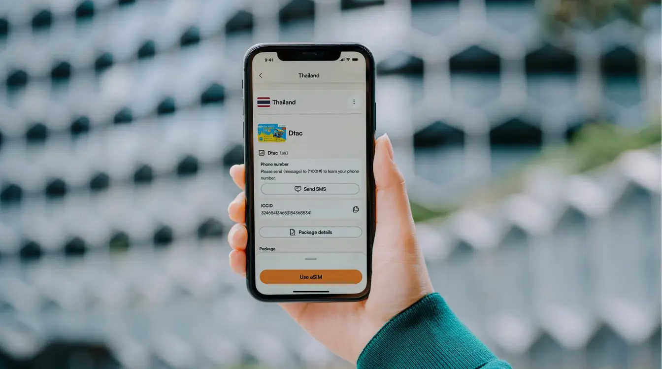 Viajante com celular em mãos e app da Airalo na tela.