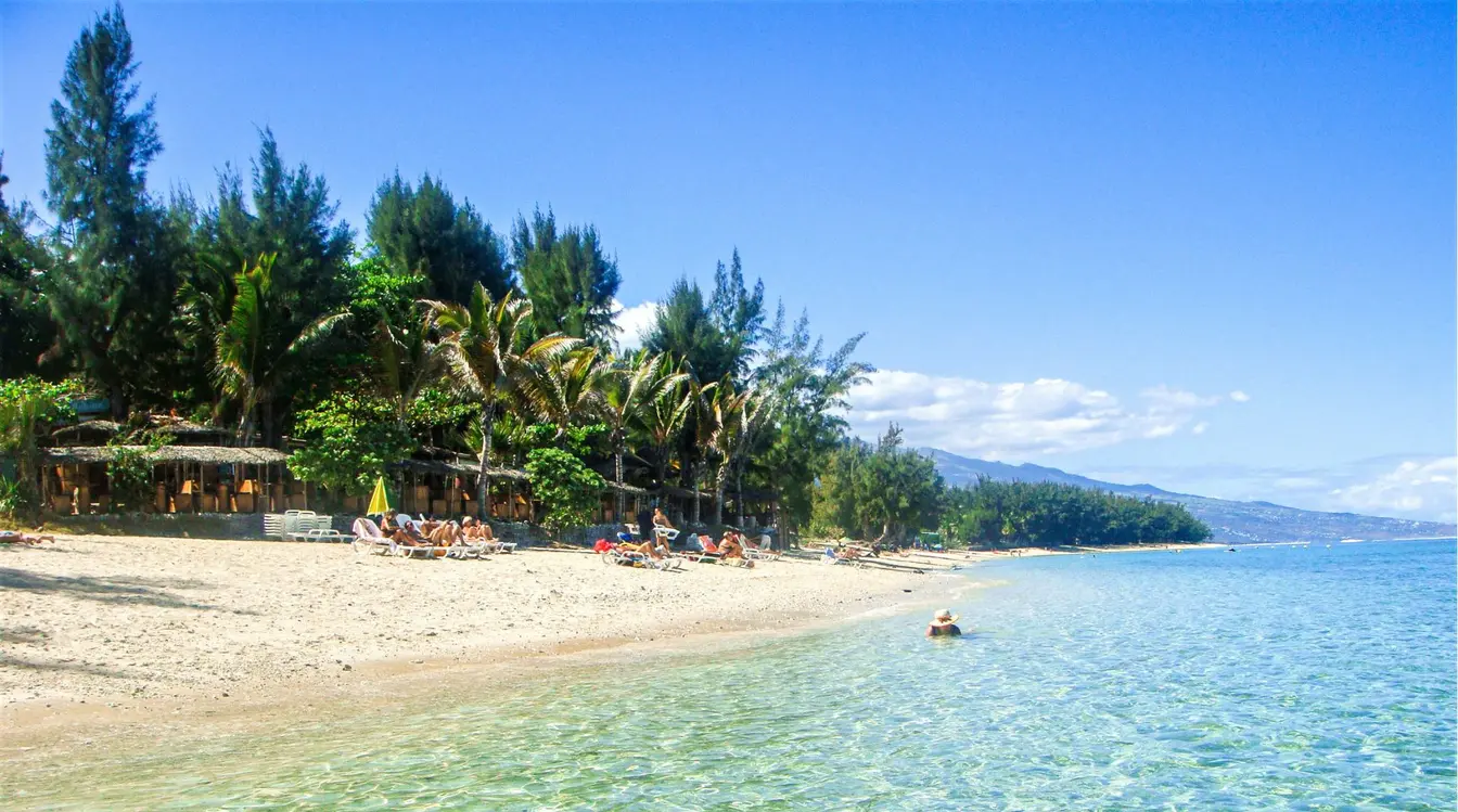 Plage de Saint-Gilles à La Réunion, avec son lagon protégé, son sable blanc et ses filaos en bord de mer.