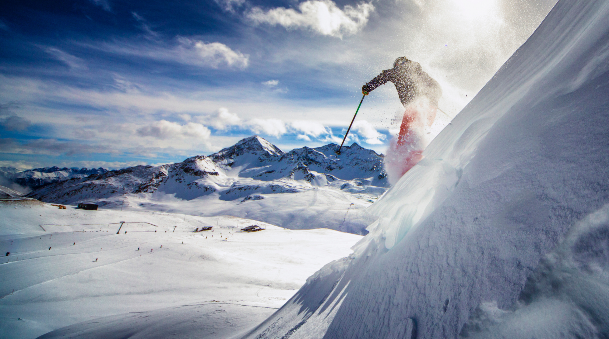 Sciatore in discesa su neve fresca in alta montagna, immagine ideale per raccontare una vacanza sulla neve in Europa.