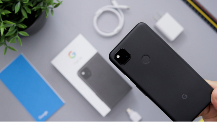 Hand holding a black Google Pixel above its box and charger, suggesting simple Google Pixel eSIM setup and switching for travellers, to illustrate a blog post entitled 'Are Google Pixel Phones eSIM Compatible?'