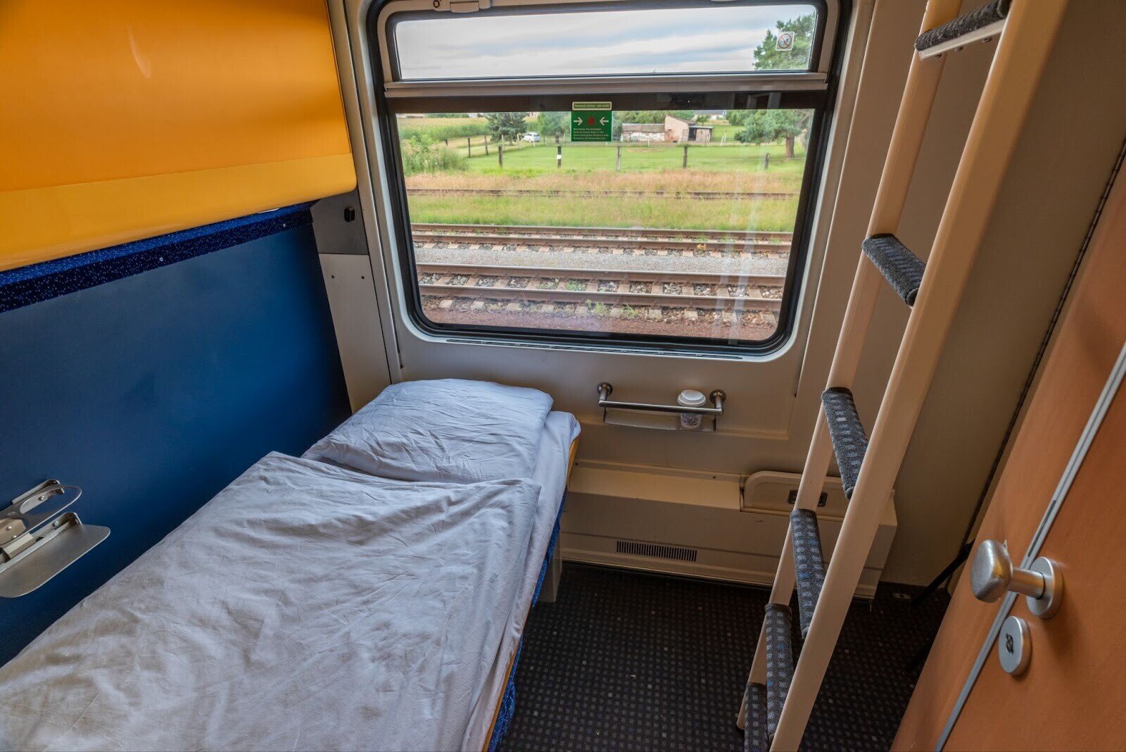 Private sleeper cabin on night train in Europe with bunk bed and window view