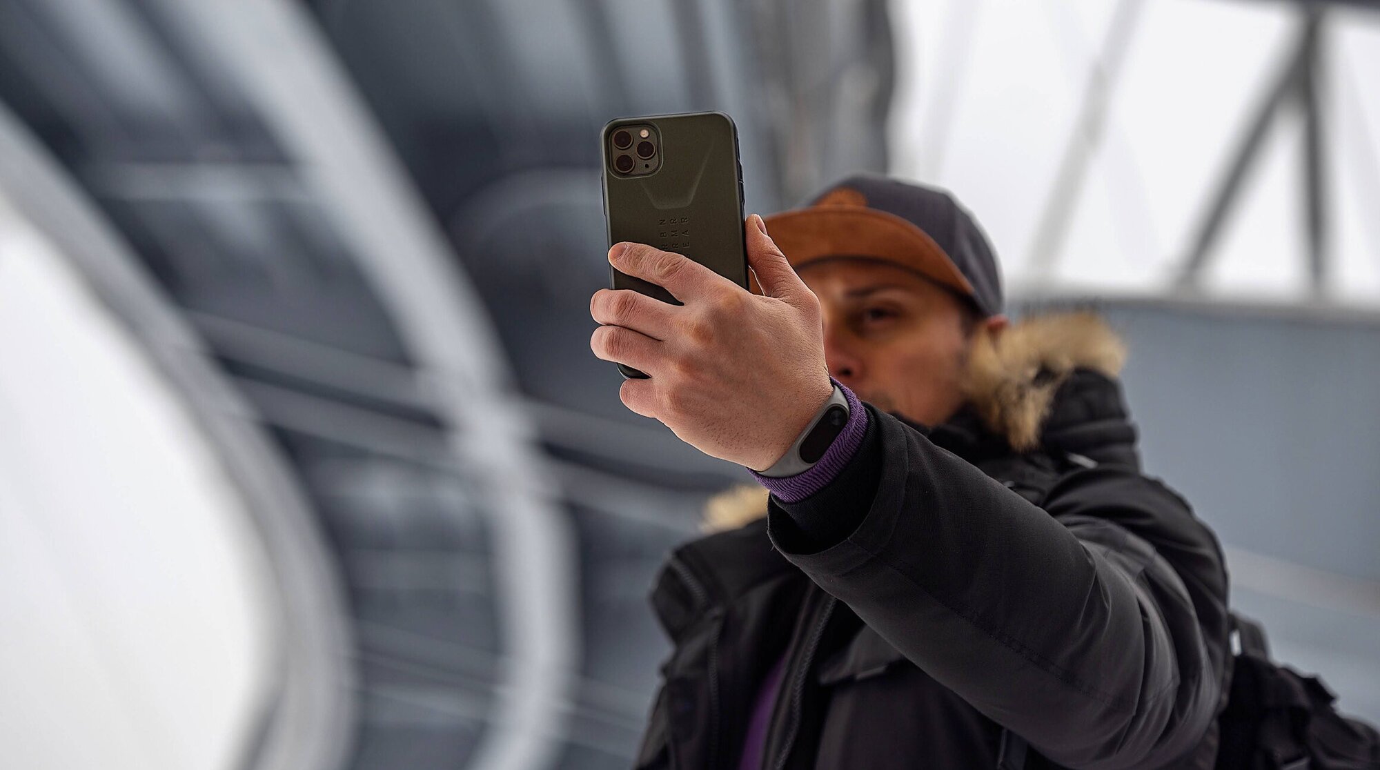 Man holding smartphone under the Eiffel Tower.