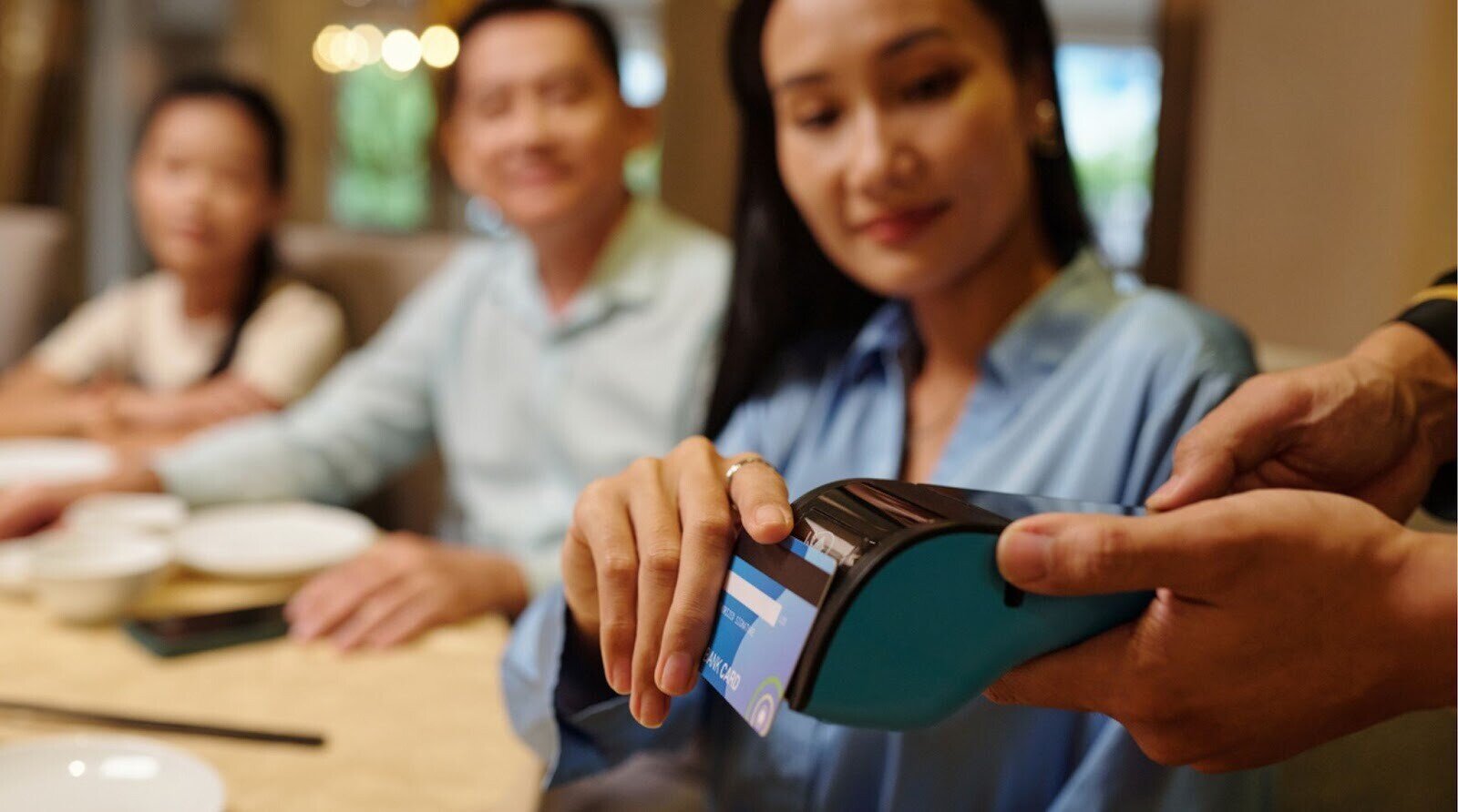 Touriste payant son repas avec une carte bancaire sans frais dans un restaurant à Hanoï, Vietnam