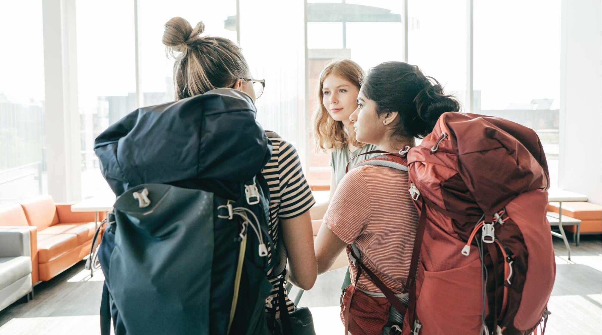 grupo de jovens viajantes mochileiras no hall de um hotel.