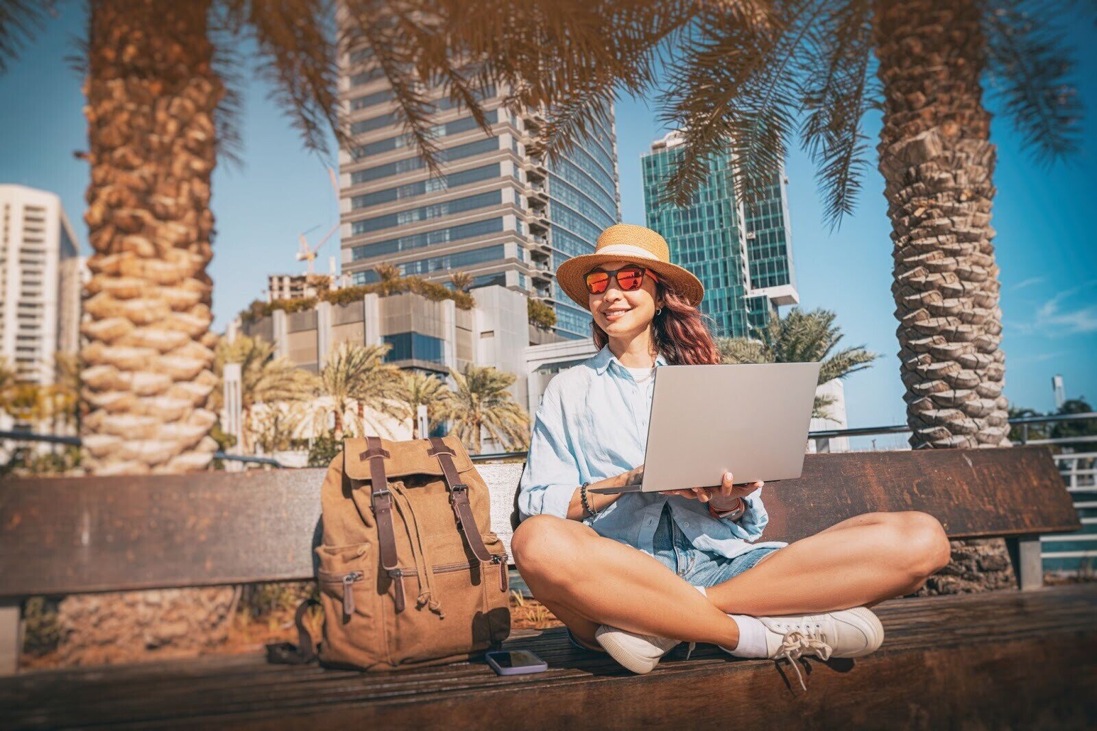 Eine Frau in Dubai, die mitten in der Stadt am Laptop arbeitet