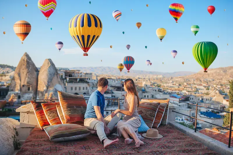 Pareja viendo globos aerostáticos en Capadocia al amanecer.