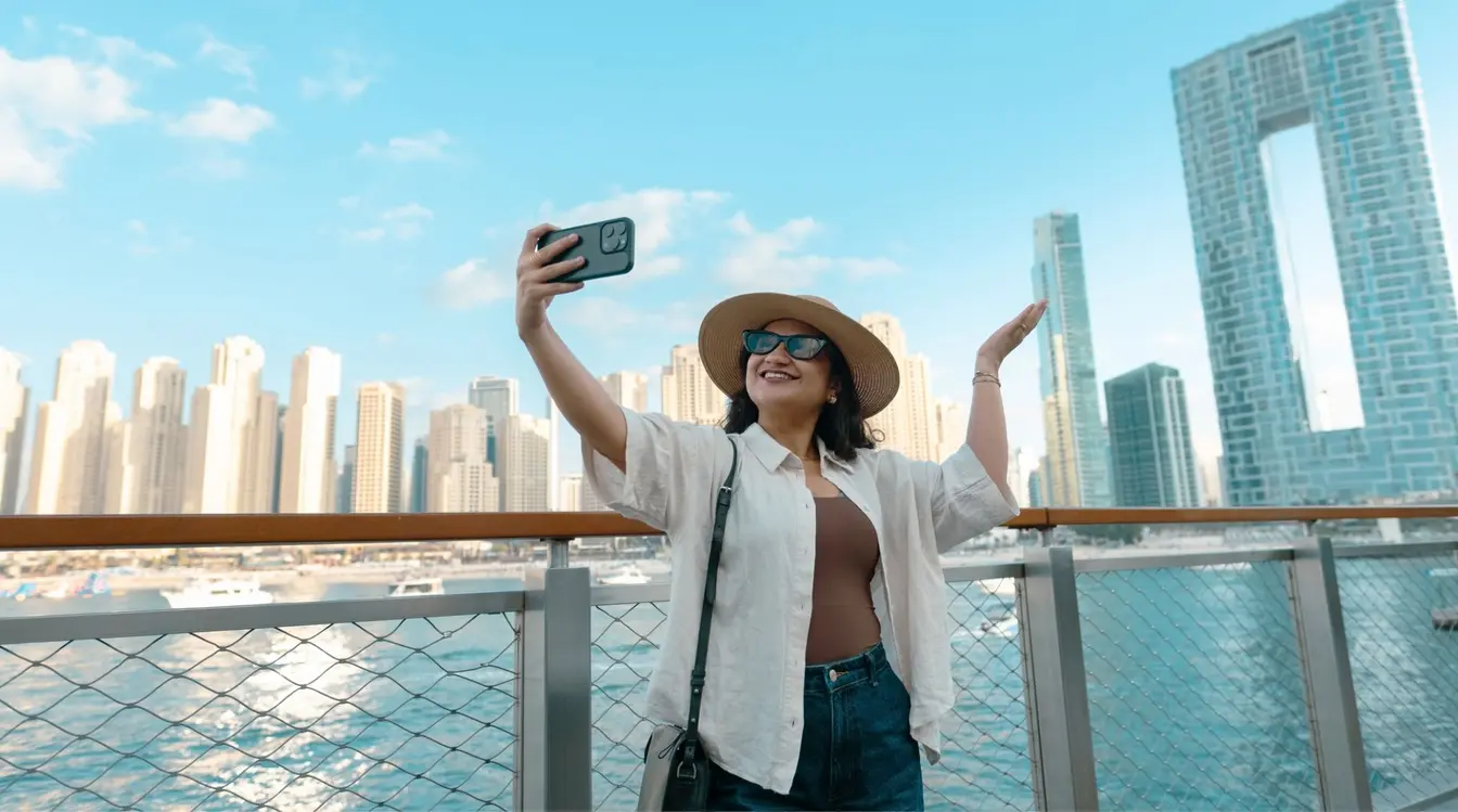 Jeune femme face à la skyline de la marina de Dubaï depuis la terrasse d’un hôtel